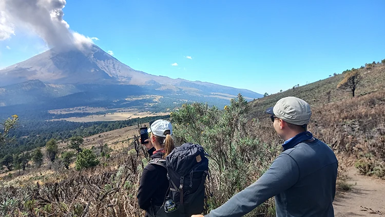 dos turistas en el nivel 2 del tour popocatepetl tomando fotos del volcan activo