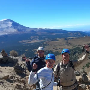 Grupo de excursionistas en la cima con vista al Popocatépetl