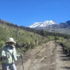Senderista caminando por sendero con vista al volcán Iztaccíhuatl