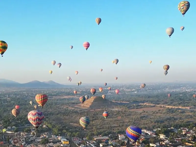 Hot air balloons flying over Teotihuacán pyramids at sunrise – unique aerial view of Mexico’s ancient site