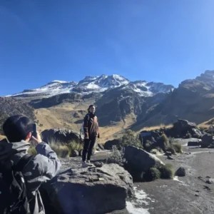 Turista posando en mirador con el Iztaccíhuatl nevado al fondo