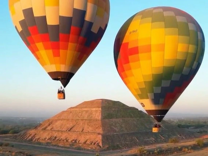 Hot air balloons flying over the Pyramid of the Sun in Teotihuacan at sunrise